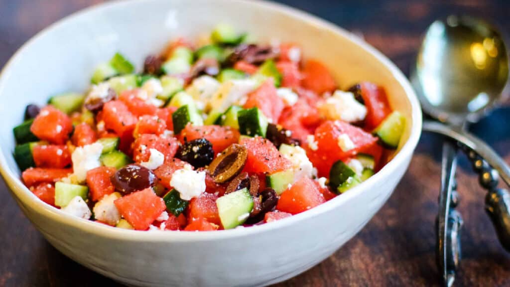 Low angle shot of a bowl of watermelon salad with kalamata olives and feta cheese.