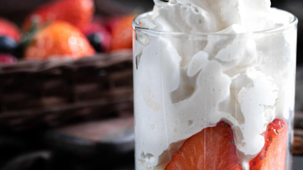Keto Whipped Cream with strawberries in a glass.