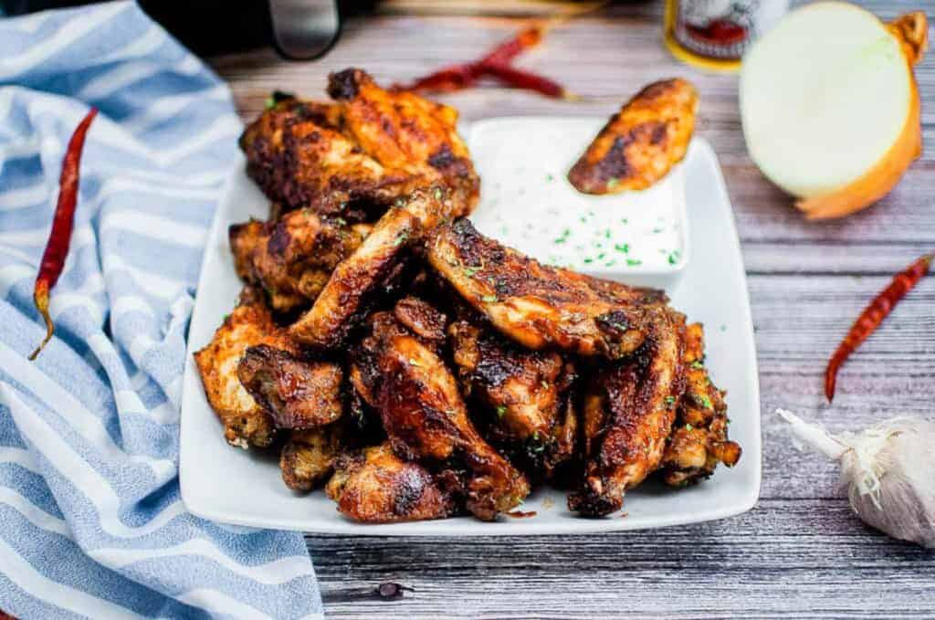 A pile of air fryer BBQ wings on a white platter.