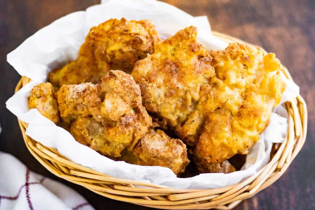 fried chicken in a basket lined with parchment paper.