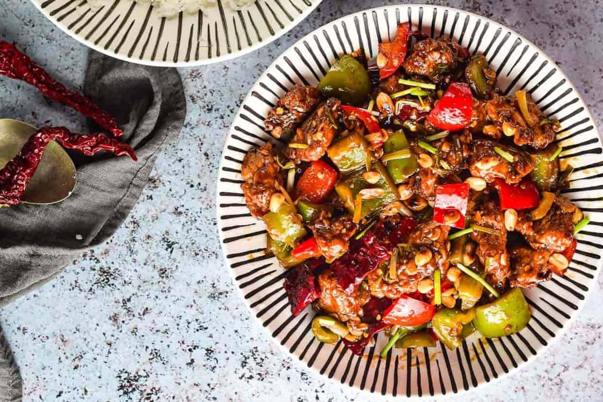 Overhead shot of a striped bowl with kung pao chicken.