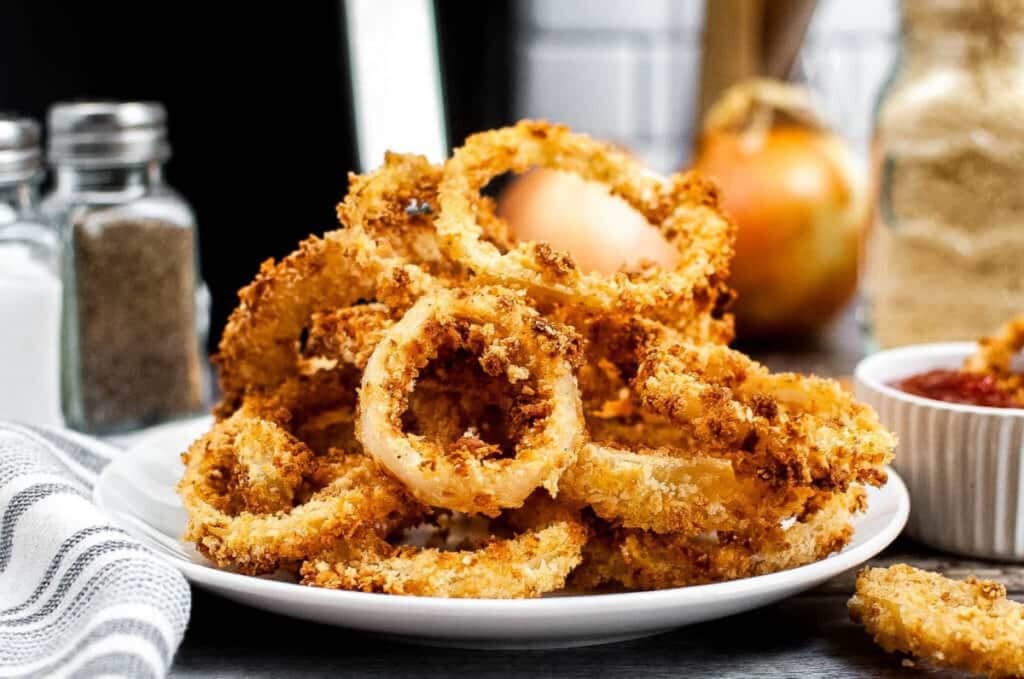 Pile of onion rings on a white plate.