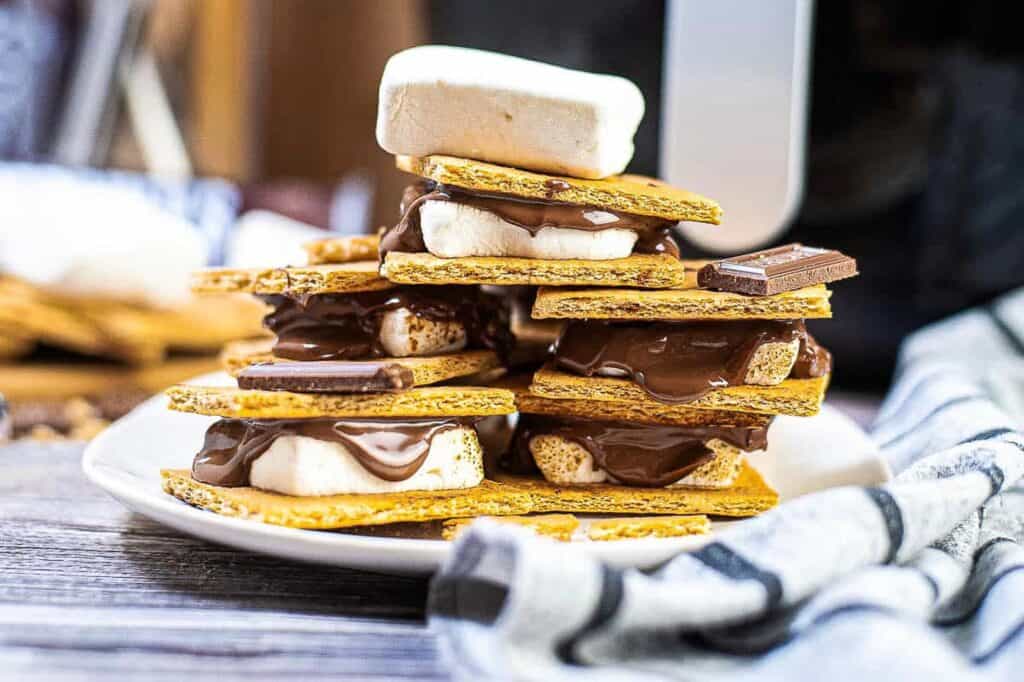 Stacked s'mores on a white plate.