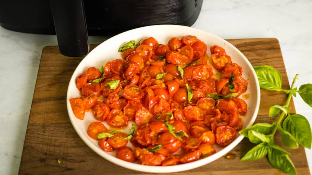 plate of air fryer tomatoes topped with basil.