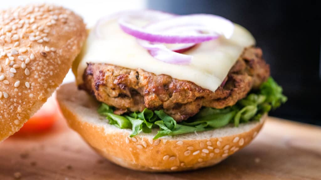 turkery burger on a bun with lettuce, cheese and red onion.