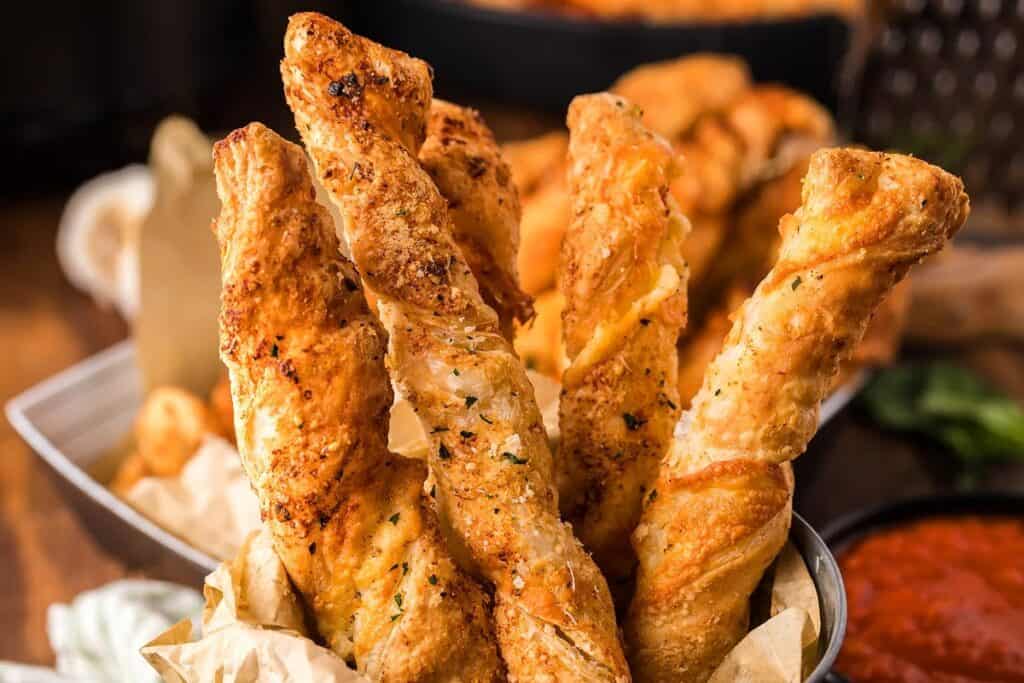 Several cheese pastry twists in a bowl.
