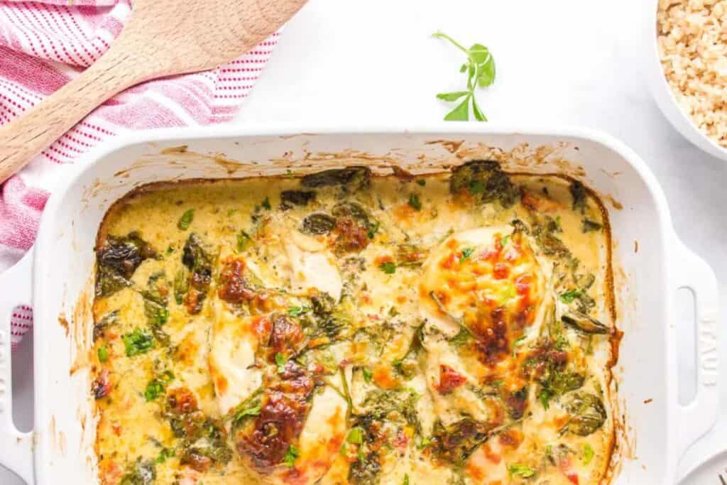 Baked Tuscan Chicken in a white casserole dish.