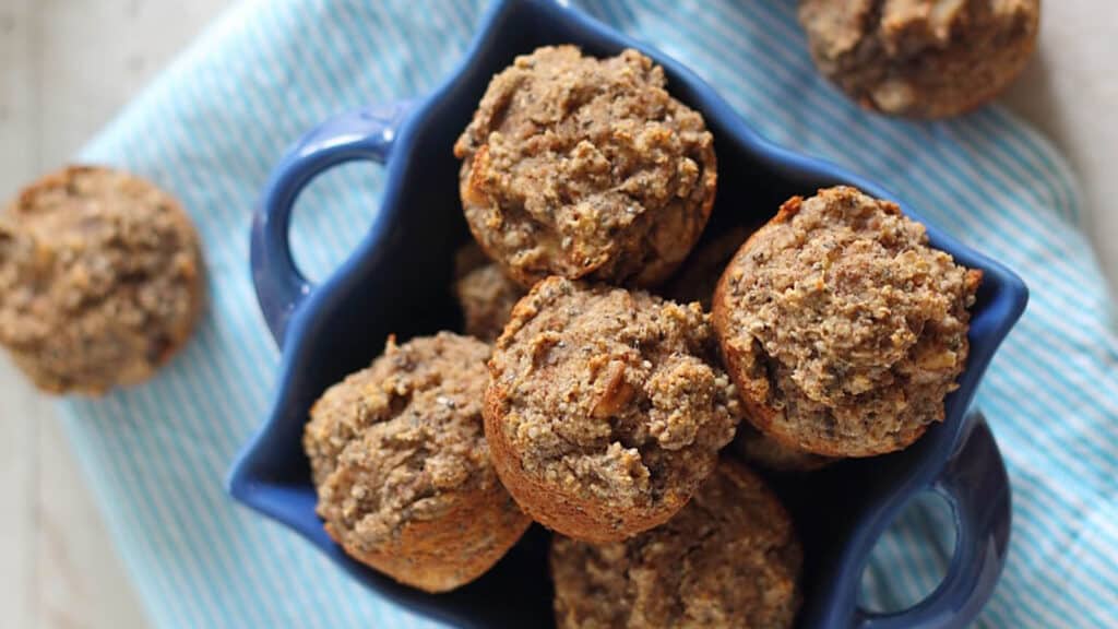 Banana chia mini muffin bites in a blue ceramic basket.