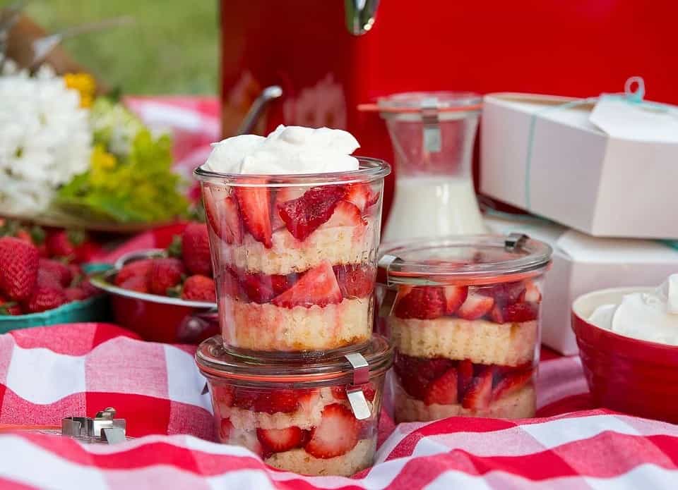 A picnic with individual strawberry shortcakes in jars.