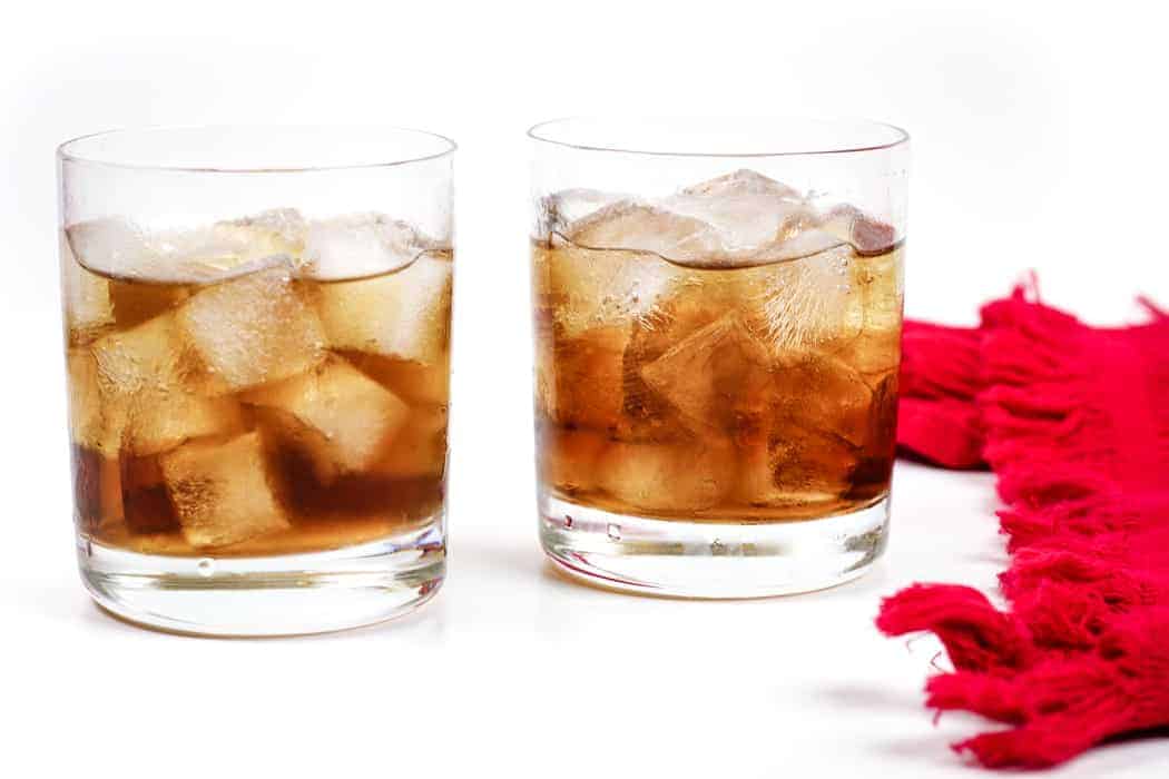 two black Russian cocktails with a red kitchen towel.