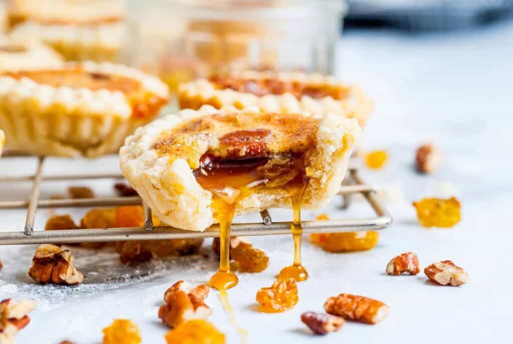 A gooey butter tart with a bite out of it on a wire rack. 