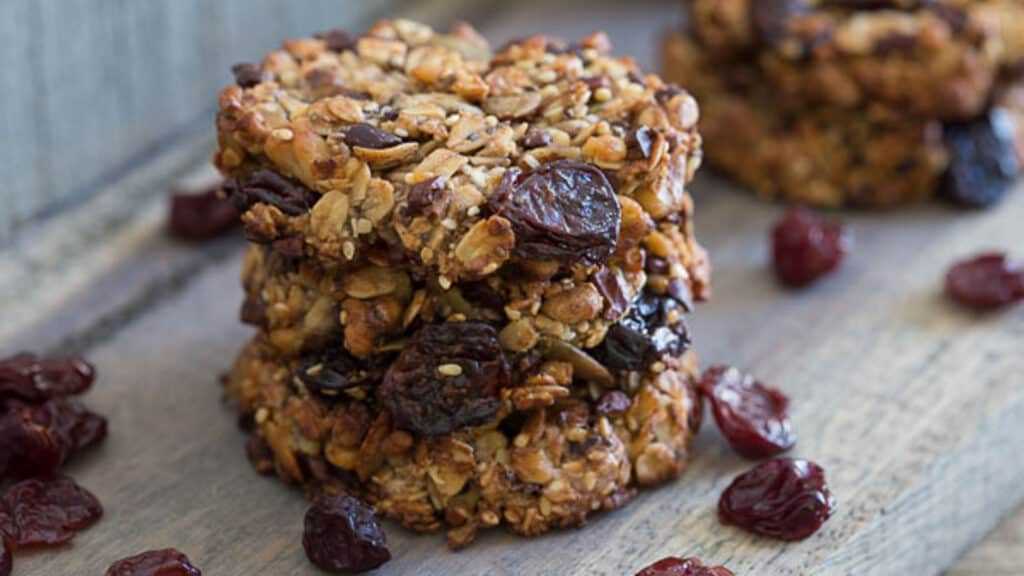 Cherry power cookies in a stack with dried cherries scattered around.