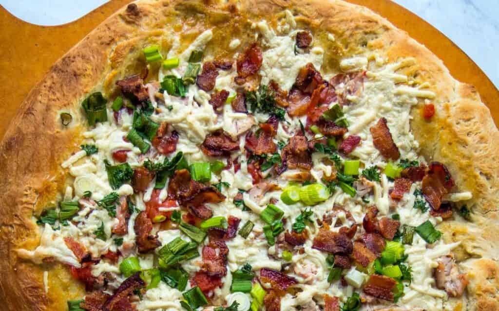 Chicken bacon ranch pizza on a pizza peel.