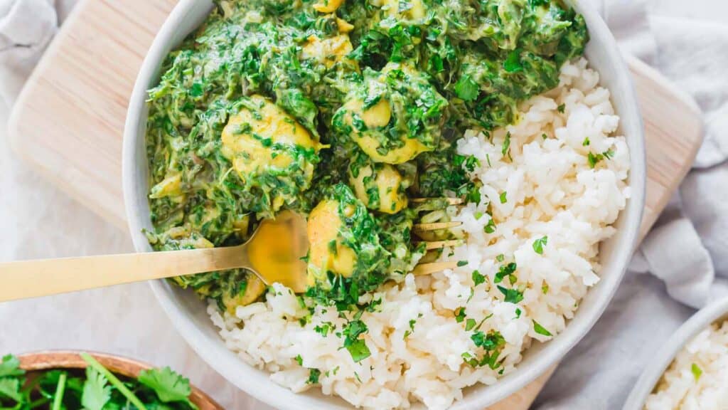 Chicken saag in a bowl with white rice.