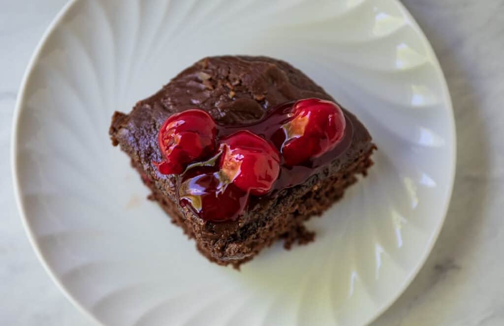 Chocolate cherry cake top view with cherries on top.