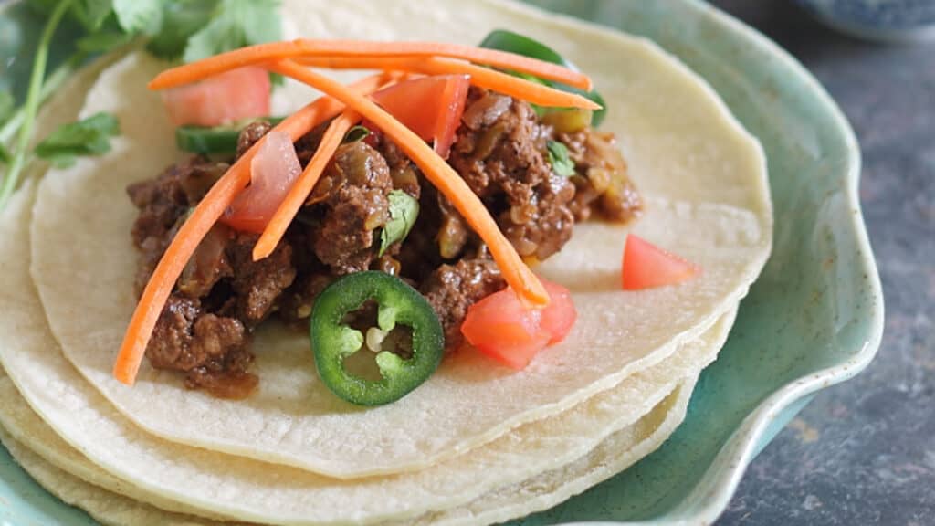 Chocolate chile beef tacos on soft tortillas.
