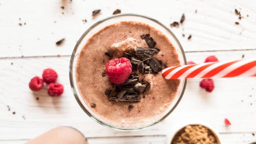 Chocolate Raspberry Smoothie in glass with red and white straw
