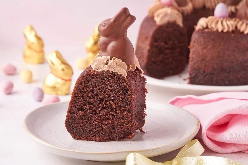 A slice of chocolate bundt cake with a chocolate bunny on top.