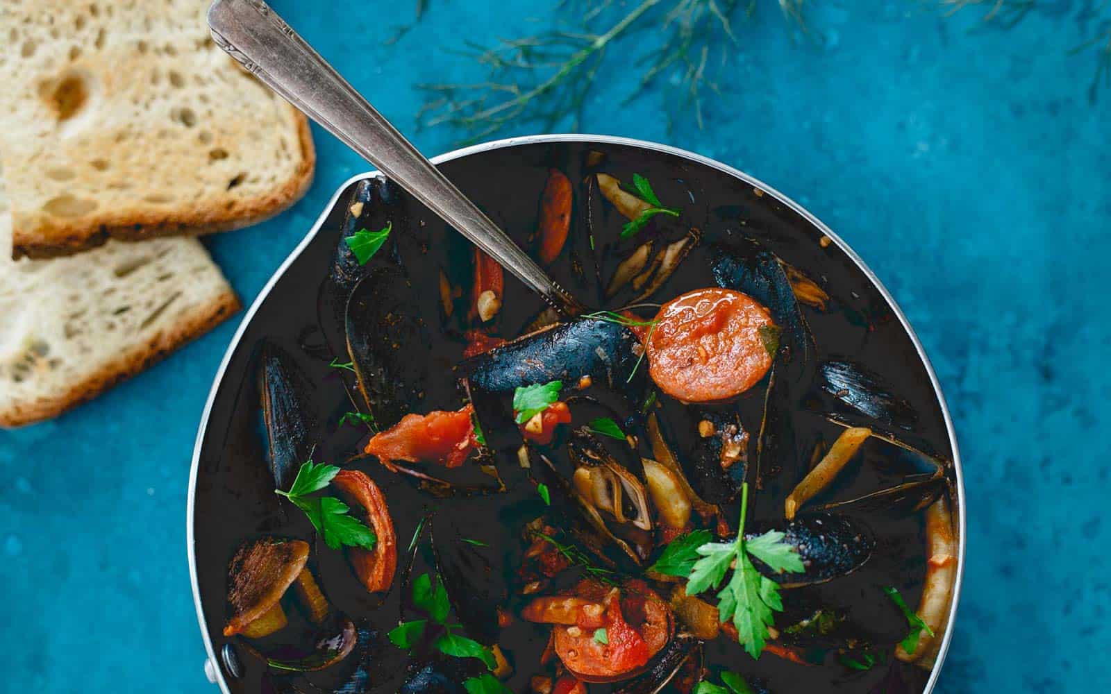 Mussels with chorizo and chilis in a pot.