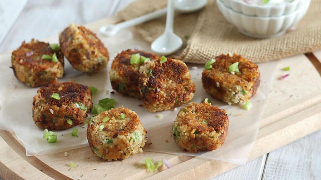 Crispy salmon bites made with canned salmon on a cutting board with dipping sauce.