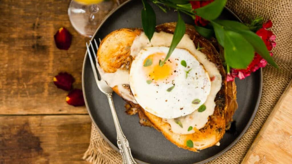 Overhead shot of croque madame on a plate with a perfectly cooked sunny side up egg.