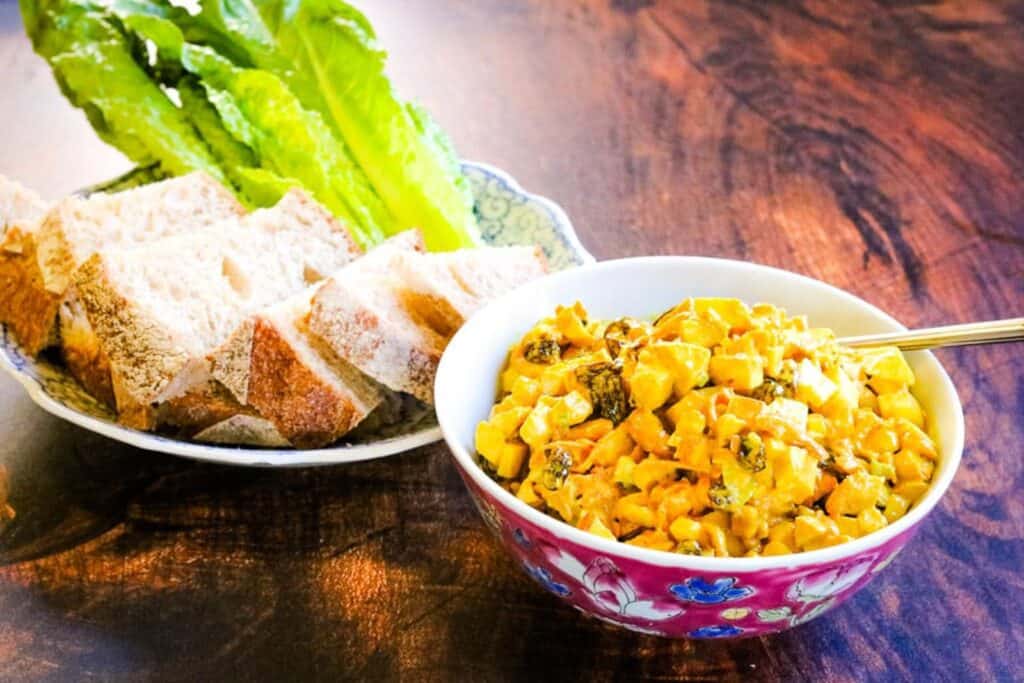 curried chicken salad with apples, raisins, and cashews in a bowl.