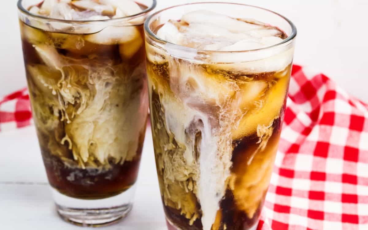 Two glasses of dirty diet coke with a red and white checked napkin.