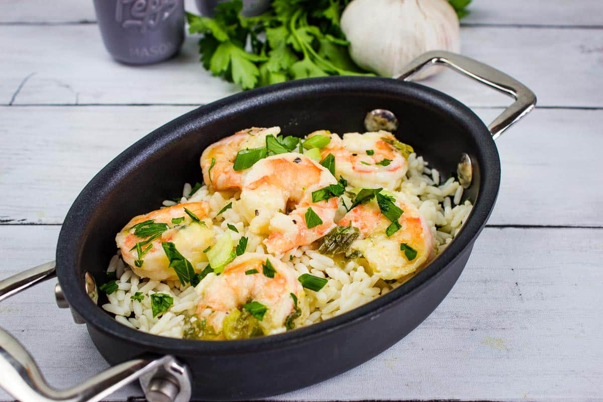 Garlic Shrimp Scampi on a bed of rice in a black oval dish.