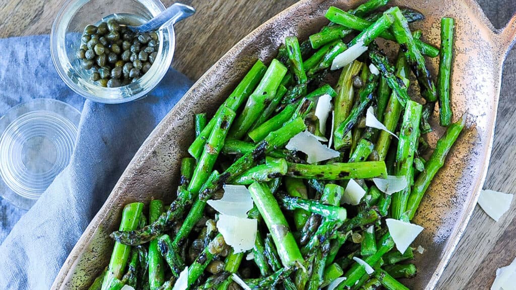 Grilled Asparagus with Lemon-Caper Vinaigrette in serving dish with side of capers.