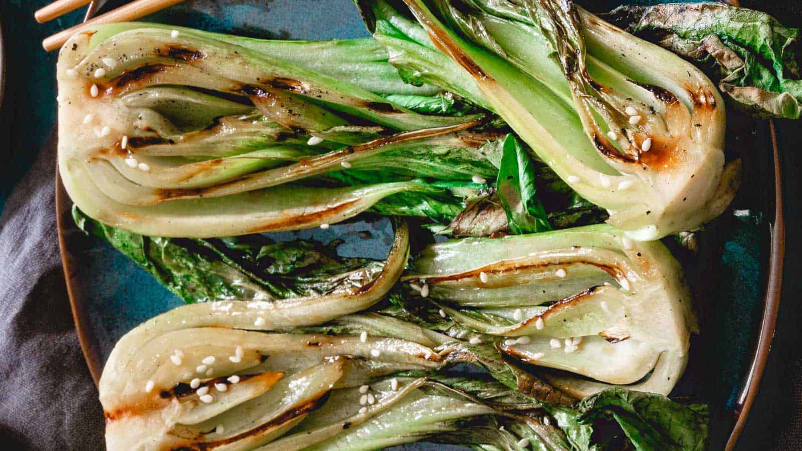 Grilled baby bok choy garnished with sesame seeds.