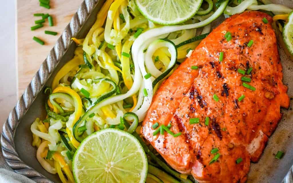 Grilled salmon with zucchini noodles and lime.