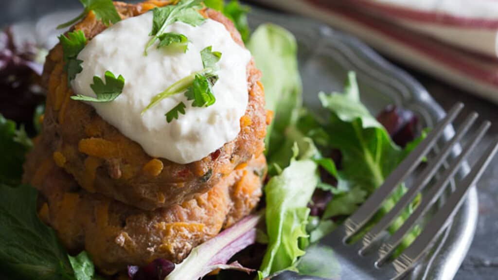 Sweet potato turkey patties stacked on baby greens.