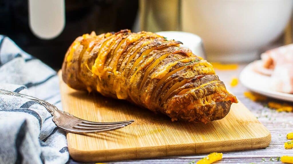 Air fryer hasselback potatoes stuffed with cheese and bacon.
