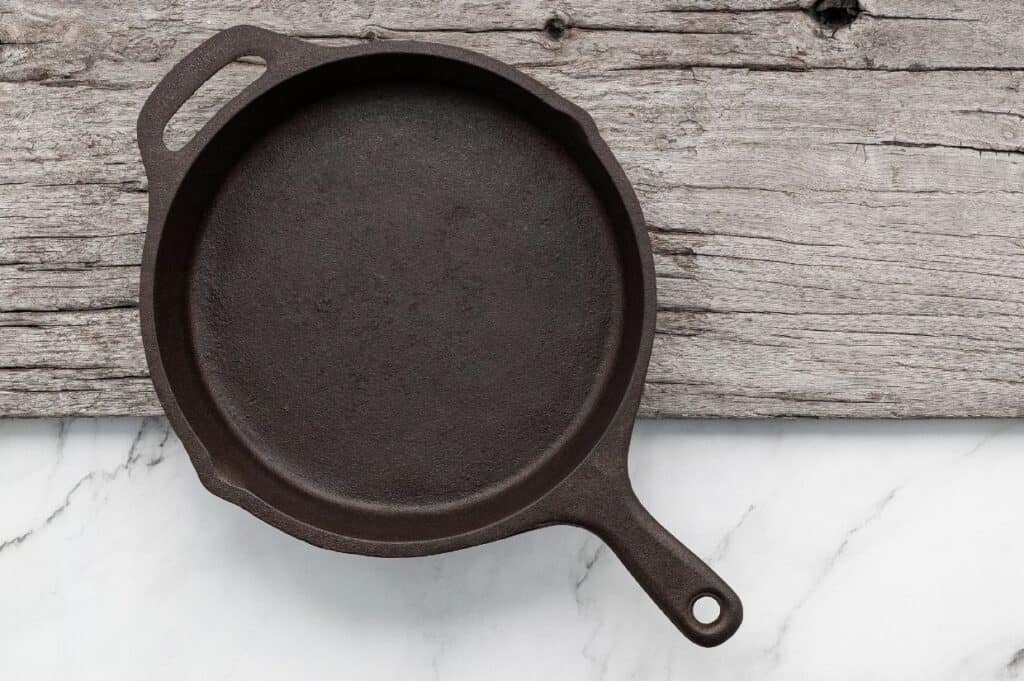 clean cast iron skillet on wooden board