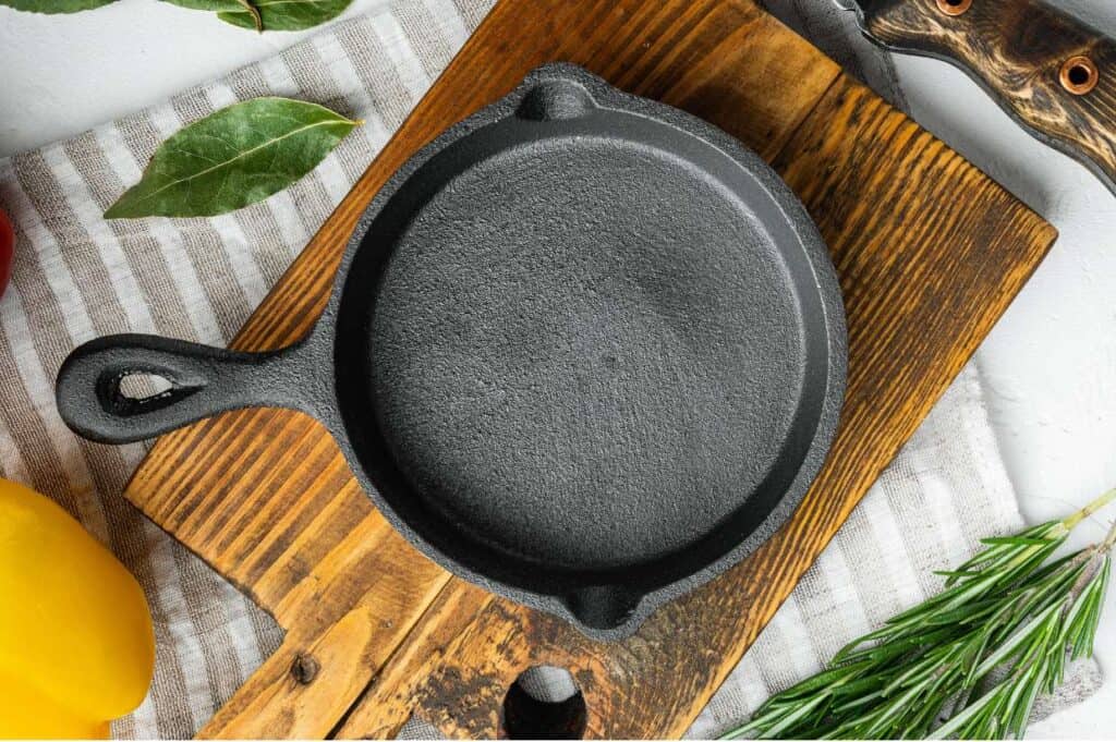 cast iron skillet on a wooden board with cloth