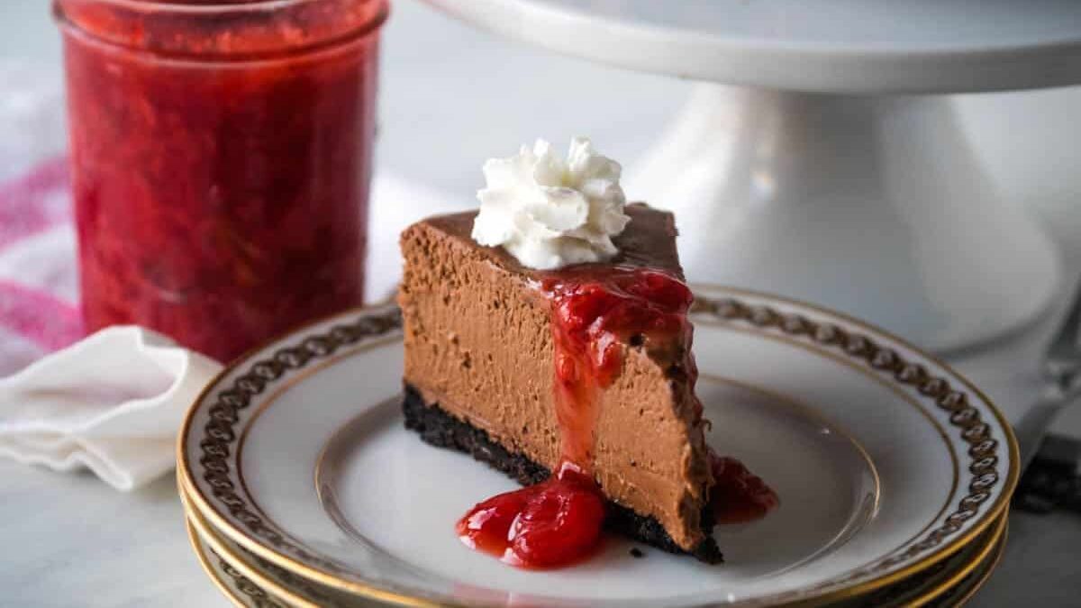 Instant Pot Chocolate Cheesecake drizzled with strawberry sauce and topped with whipped cream.
