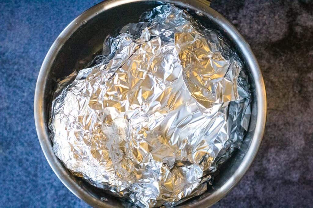 Ham wrapped in foil inside the instant pot.