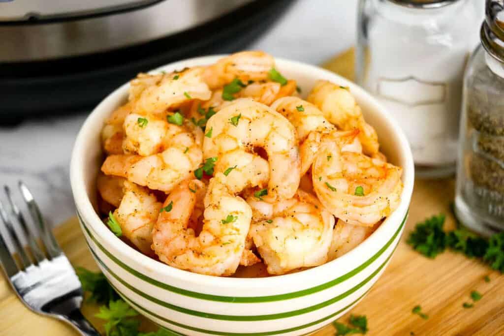 Shrimp in a green and white striped bowl.