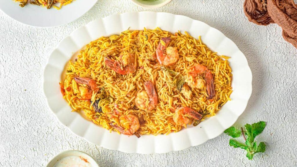 Shrimp biryani on a white platter.