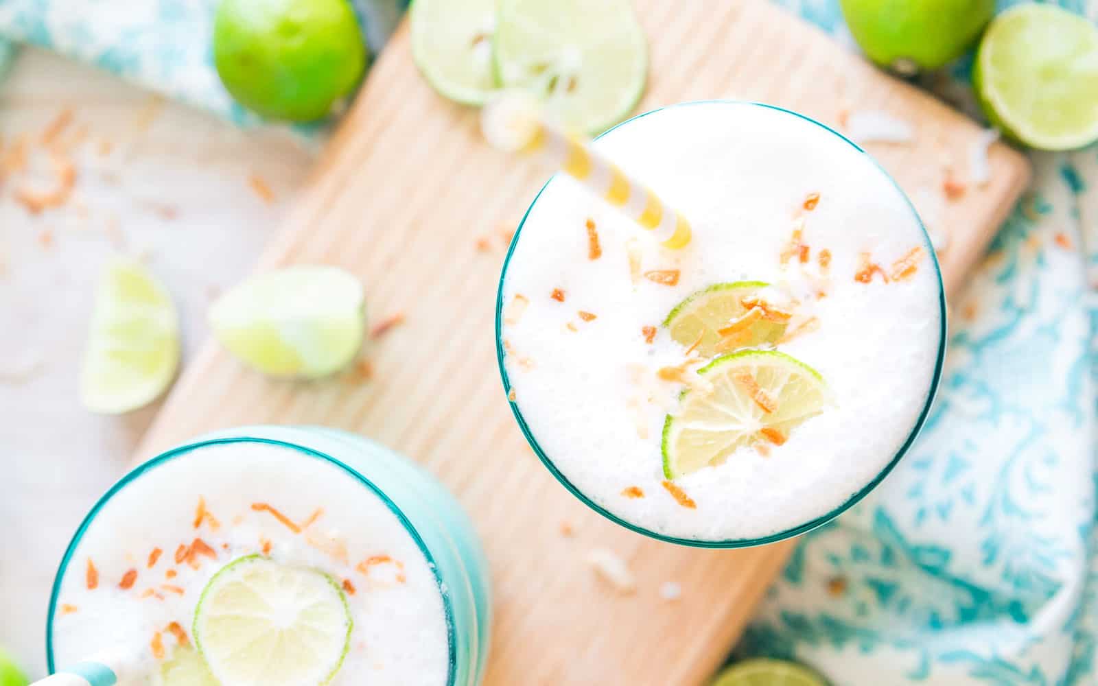 Key lime smoothie with lime and toasted coconut garnish.