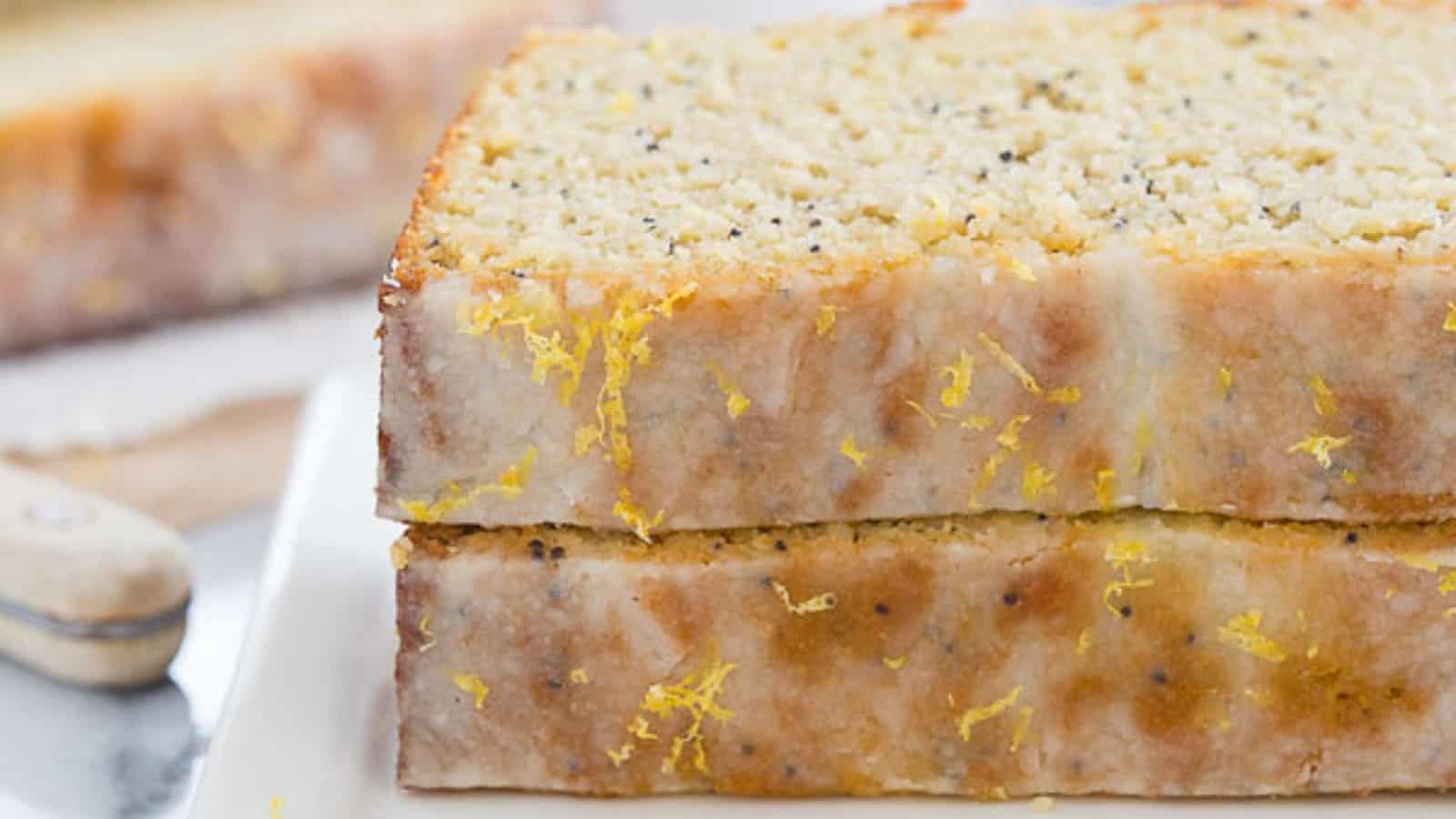 Paleo lemon poppyseed bread slices stacked on top of each other on a plate.