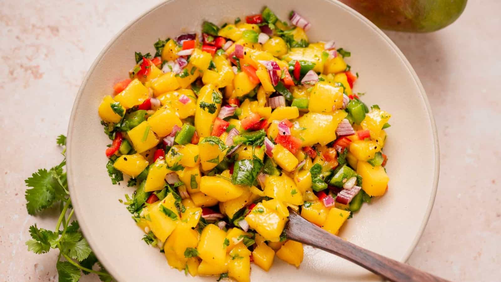 A large ceramic bowl filled with mango salsa.