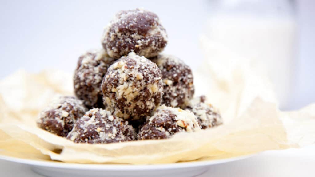 Nutella cookie dough balls stacked on a plate with parchment paper.