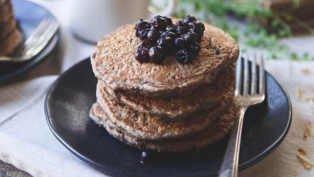 Toasted coconut cinnamon raisin oat bran pancakes with wild blueberries on top.