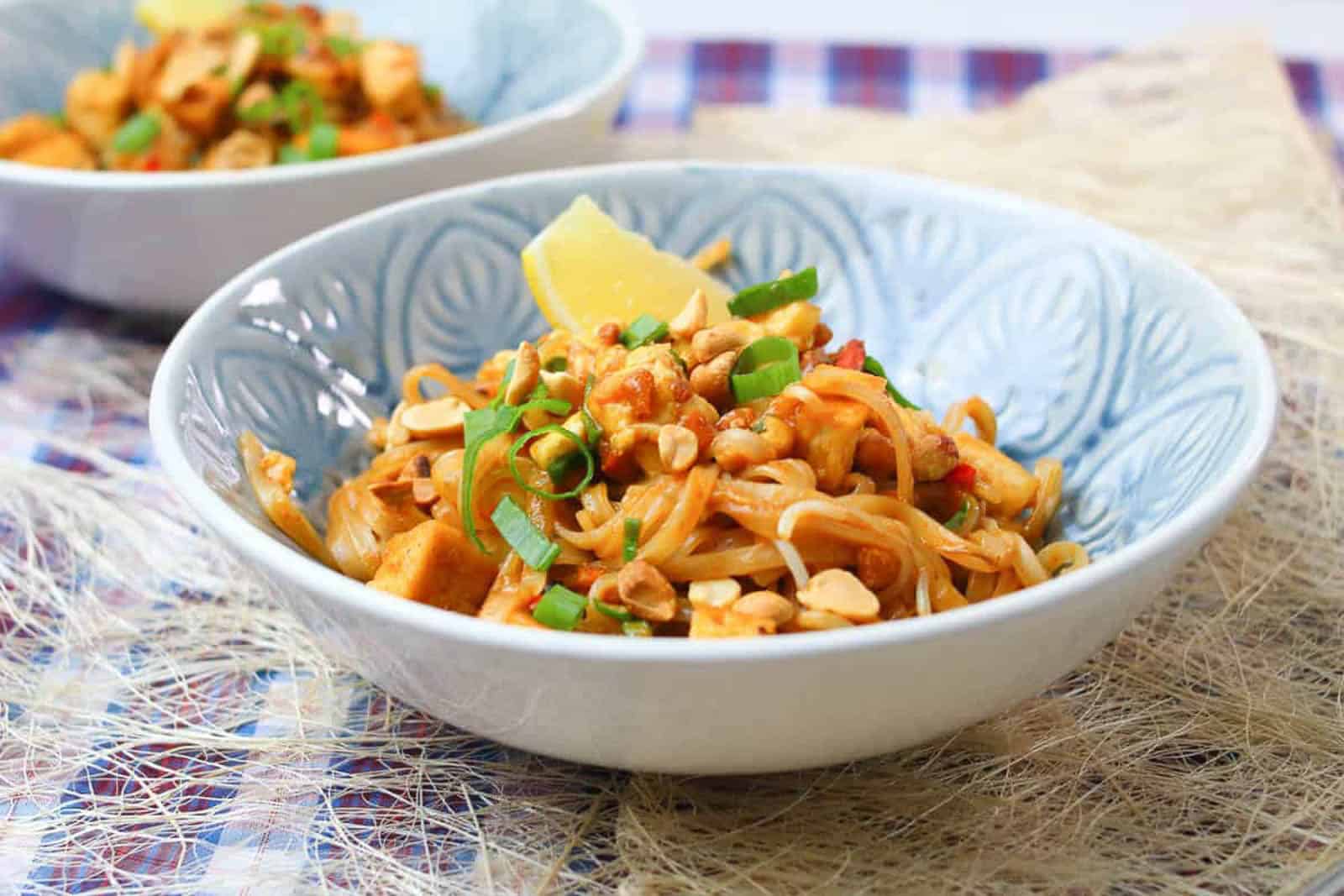 low angle shot of a light blue bowl of pad thai.