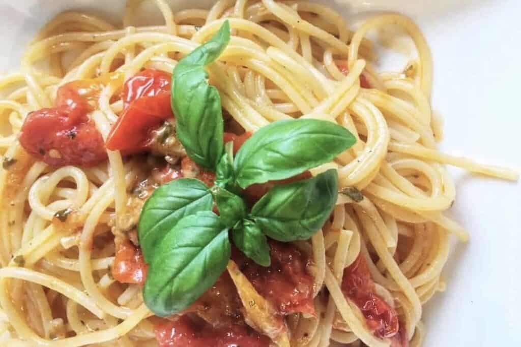 Pasta With Fresh Tomatoes on white plate.