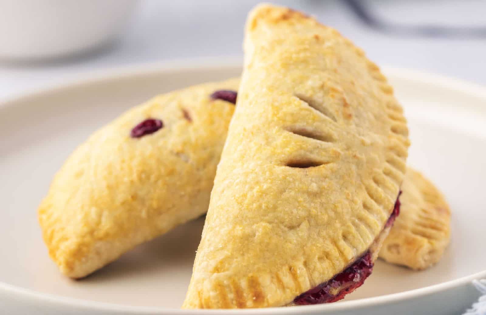 Two cherry handpies on a white plate.