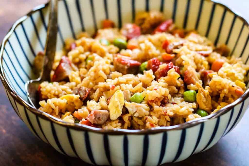 Pork fried rice in a blue and white striped bowl.