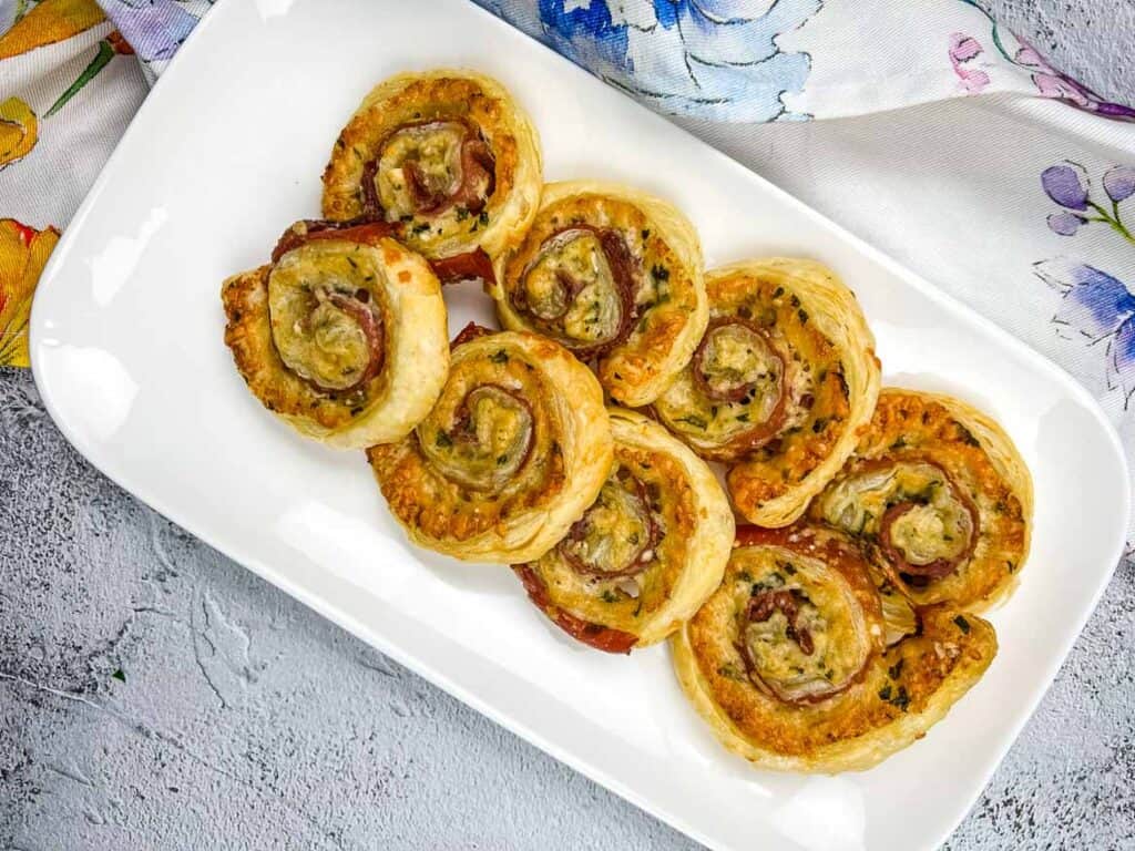 A plate of Prosciutto & Parmesan Puff Pastry pinwheels.