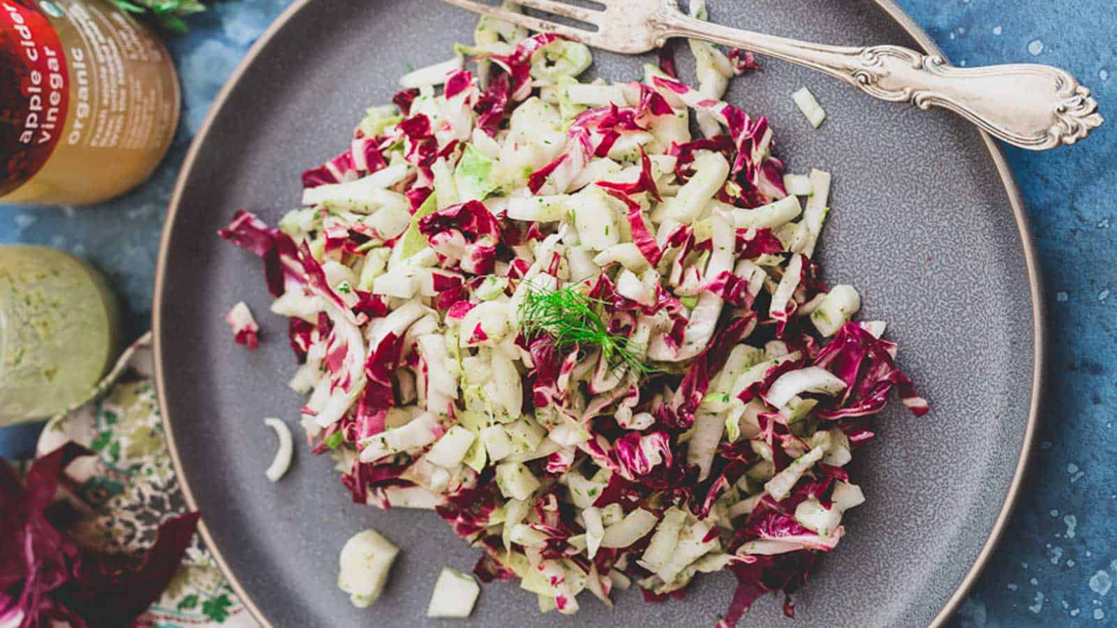 Radicchio endive fennel salad on a gray plate with a silver fork.